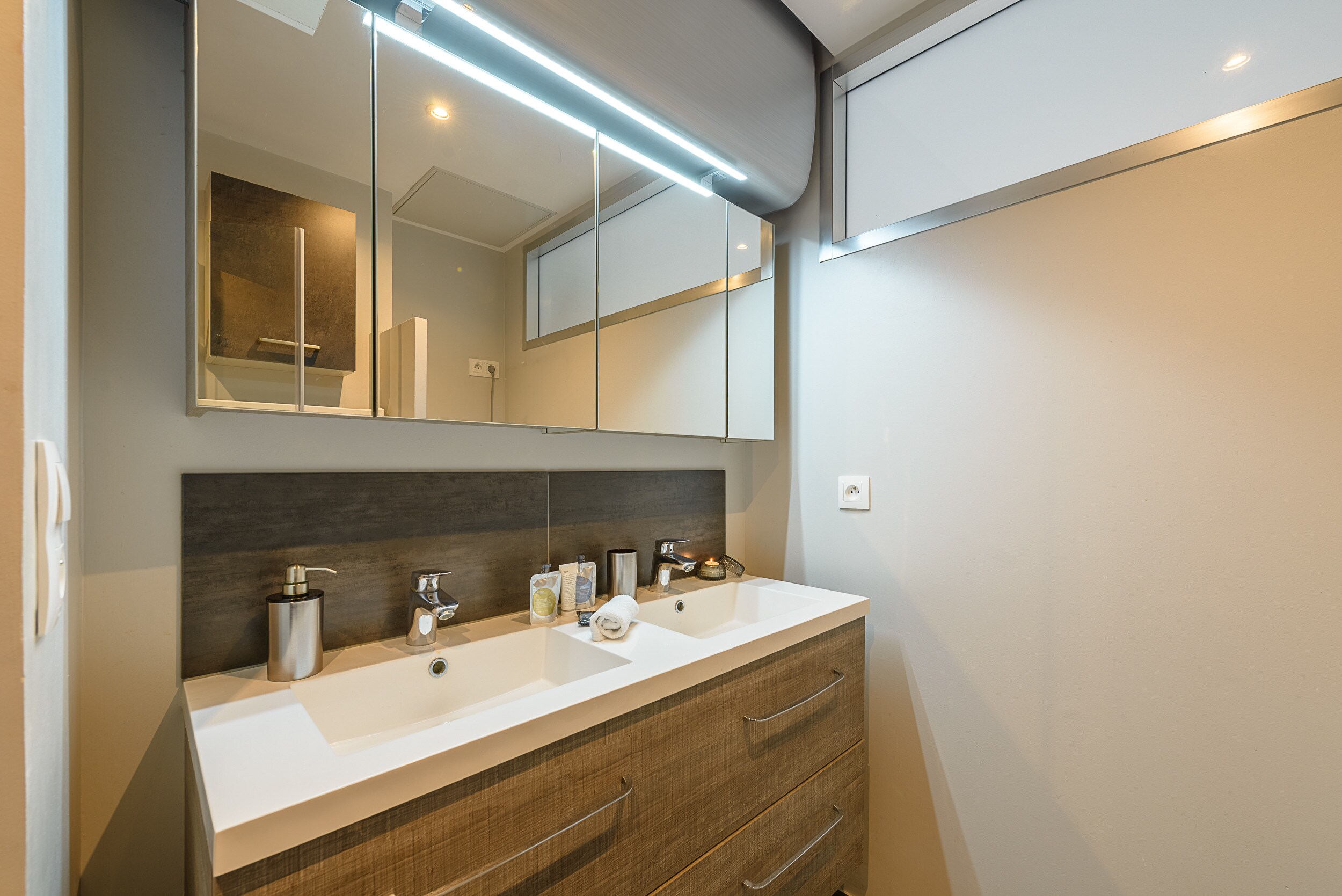 Discover our elegant shower room equipped with washing machine, shower and double basin. Enjoy the comfort and functionality of this modern shower room, ideal for all your needs during your stay. With its meticulous design and quality fittings, this shower room offers you a pleasant space.